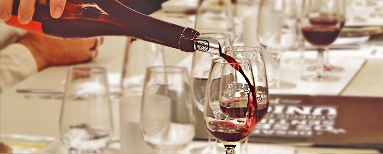 Pessoa servindo vinho tinto numa taça Pessoa servindo vinho tinto numa taça
