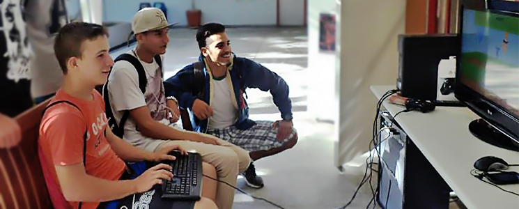 Três jovens sentados jogando no computador Três jovens sentados jogando no computador