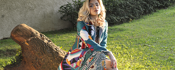 Mulher loura com roupa colorida sentada em um parque Mulher loura com roupa colorida sentada em um parque