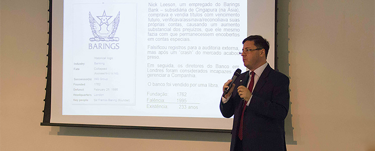 Palestrante em frente ao público, com a tela de apresentação atrás Palestrante em frente ao público, com a tela de apresentação atrás