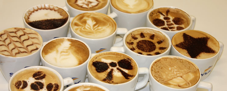 Diversas xícaras de café com desenhos em espumas feitos com a técnica latte art Diversas xícaras de café com desenhos em espumas feitos com a técnica latte art