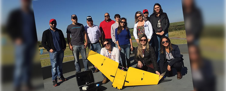 Alunos e drone amarelo em pista de decolagem Alunos e drone amarelo em pista de decolagem