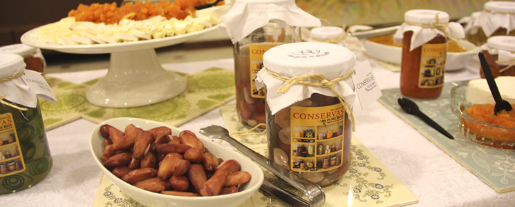 Mesa com potes de conservas e recipiente com pinhão Mesa com potes de conservas e recipiente com pinhão