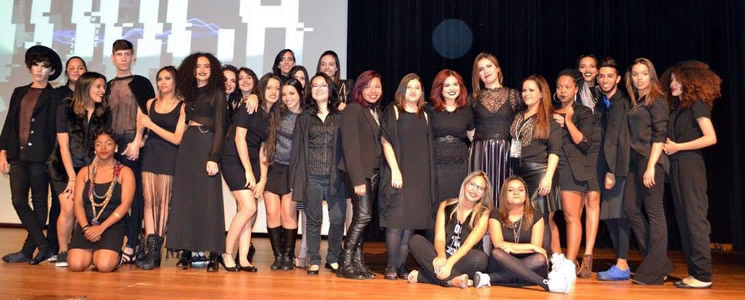 Ao lado da docente Laura Nobrega, alunos do curso Técnico em Produção de Moda posam para foto em palco do evento Touch Fashion Show Ao lado da docente Laura Nobrega, alunos do curso Técnico em Produção de Moda posam para foto em palco do evento Touch Fashion Show