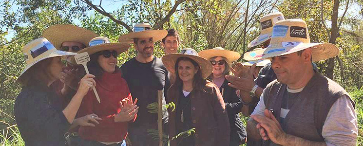 Turma de visitantes posa em frente aos cafeeiros. Turma de visitantes posa em frente aos cafeeiros.