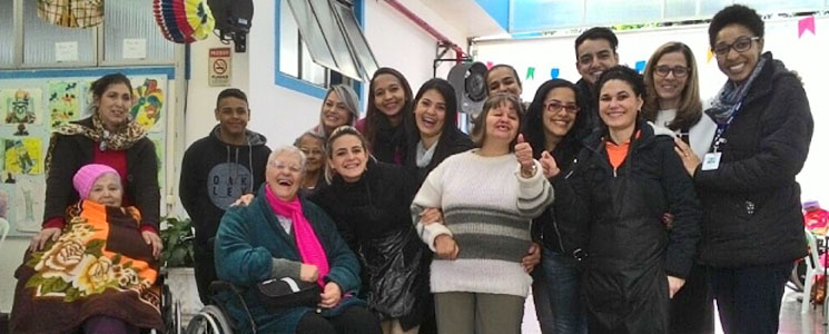 Alunos posam com senhoras atendidas pelo projeto. Alunos posam com senhoras atendidas pelo projeto.