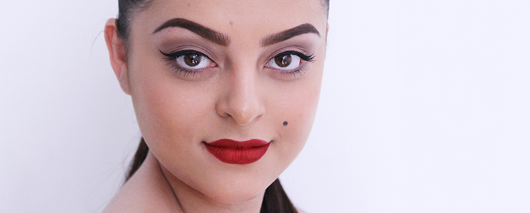 Modelo em fundo branco com batom vermelho e olhos delineados representando a década de 1940 Modelo em fundo branco com batom vermelho e olhos delineados representando a década de 1940