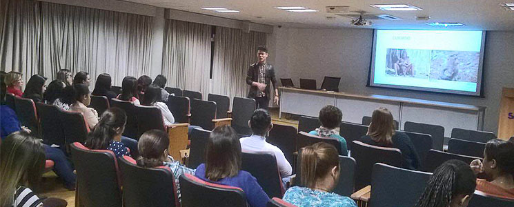 Participantes assistem à palestra de Eduardo Sodré de Souza, de pé à frente. Participantes assistem à palestra de Eduardo Sodré de Souza, de pé à frente.