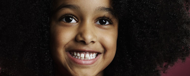 Menina sorrindo abertamente, mostrando dentes saudáveis Menina sorrindo abertamente, mostrando dentes saudáveis