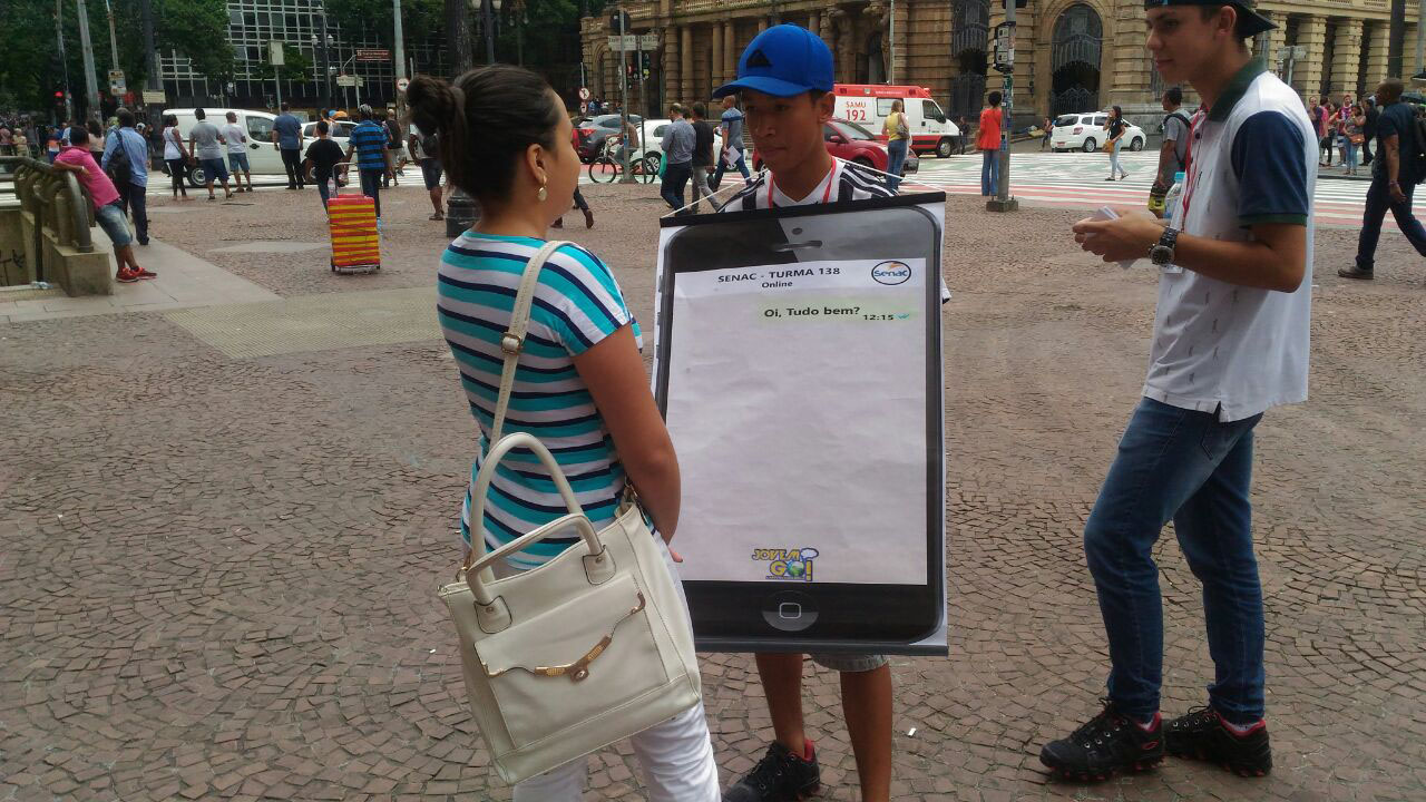 Jovem segura cartaz enquanto conversa com uma mulher Jovem segura cartaz enquanto conversa com uma mulher