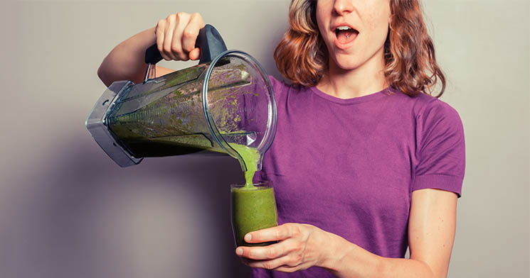 Mulher segura copo de suco verde Mulher segura copo de suco verde