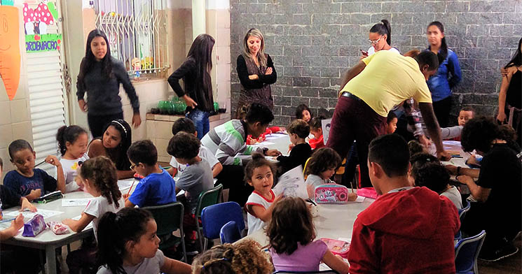Jovens interagindo com as crianças em uma sala de aula Jovens interagindo com as crianças em uma sala de aula