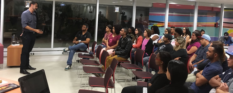Público acompanha apresentação de palestrante Público acompanha apresentação de palestrante