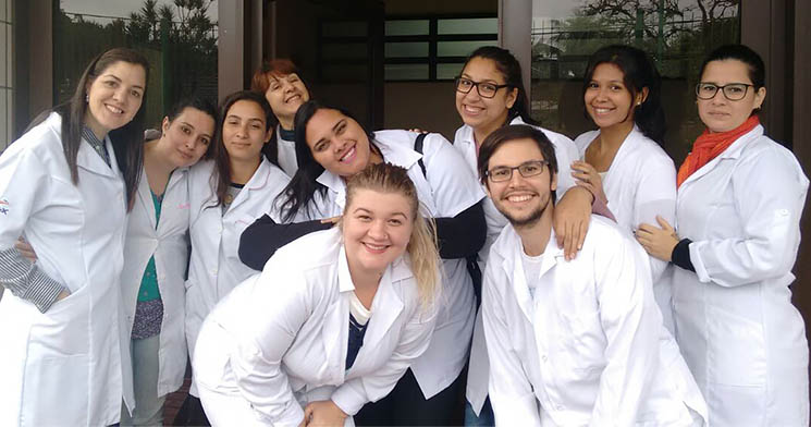 Alunos reunidos, vestidos de branco, sorrindo Alunos reunidos, vestidos de branco, sorrindo