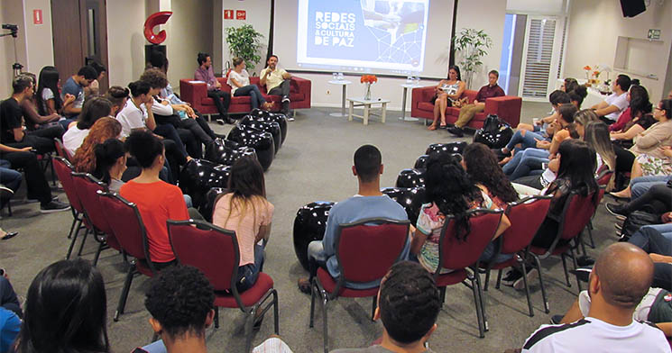 Sala, com várias pessoas sentadas, em círculo Sala, com várias pessoas sentadas, em círculo