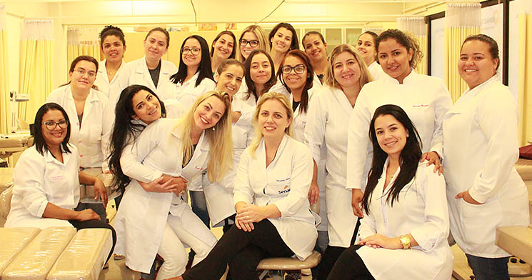 Alunas do curso Técnico em Estética do Senac Santana enfileiradas e sorridentes, com jalecos e paramentação para atendimento no Hospital Mandaqui Alunas do curso Técnico em Estética do Senac Santana enfileiradas e sorridentes, com jalecos e paramentação para atendimento no Hospital Mandaqui
