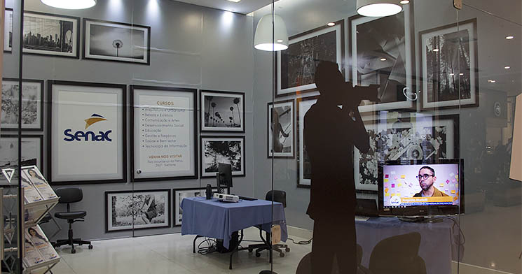 Sala com quadros nas paredes e homem com câmera fotográfica Sala com quadros nas paredes e homem com câmera fotográfica