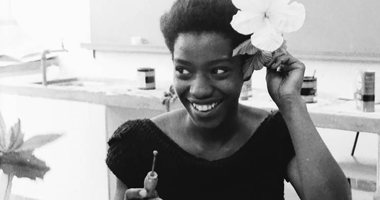 Mulher sorridente encaixa flor sobre a orelha durante aula em unidade móvel do Senac, em 1984 Mulher sorridente encaixa flor sobre a orelha durante aula em unidade móvel do Senac, em 1984