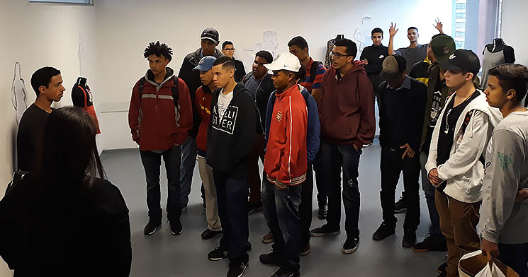 Jovem explica exposição para grupo de jovens Jovem explica exposição para grupo de jovens