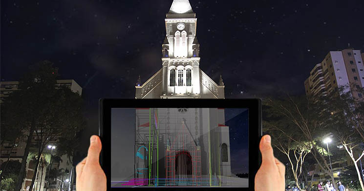 Mão segura tablet com maquete digital colorida em frente à igreja matriz de Catanduva Mão segura tablet com maquete digital colorida em frente à igreja matriz de Catanduva