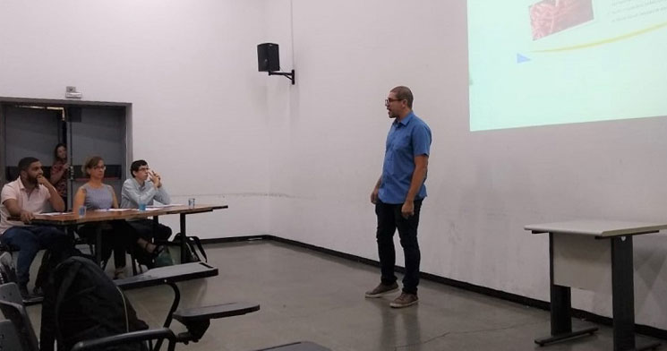 Professor apresentando trabalho em Power Point em sala de aula e tres pessoas sentadas. Professor apresentando trabalho em Power Point em sala de aula e tres pessoas sentadas.
