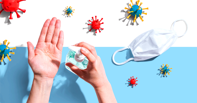 Imagem com mão aplicando álcool gel, máscara branca para proteger boca e nariz e ilustrações vermelhas e azuis que simulam vírus. Imagem com mão aplicando álcool gel, máscara branca para proteger boca e nariz e ilustrações vermelhas e azuis que simulam vírus.