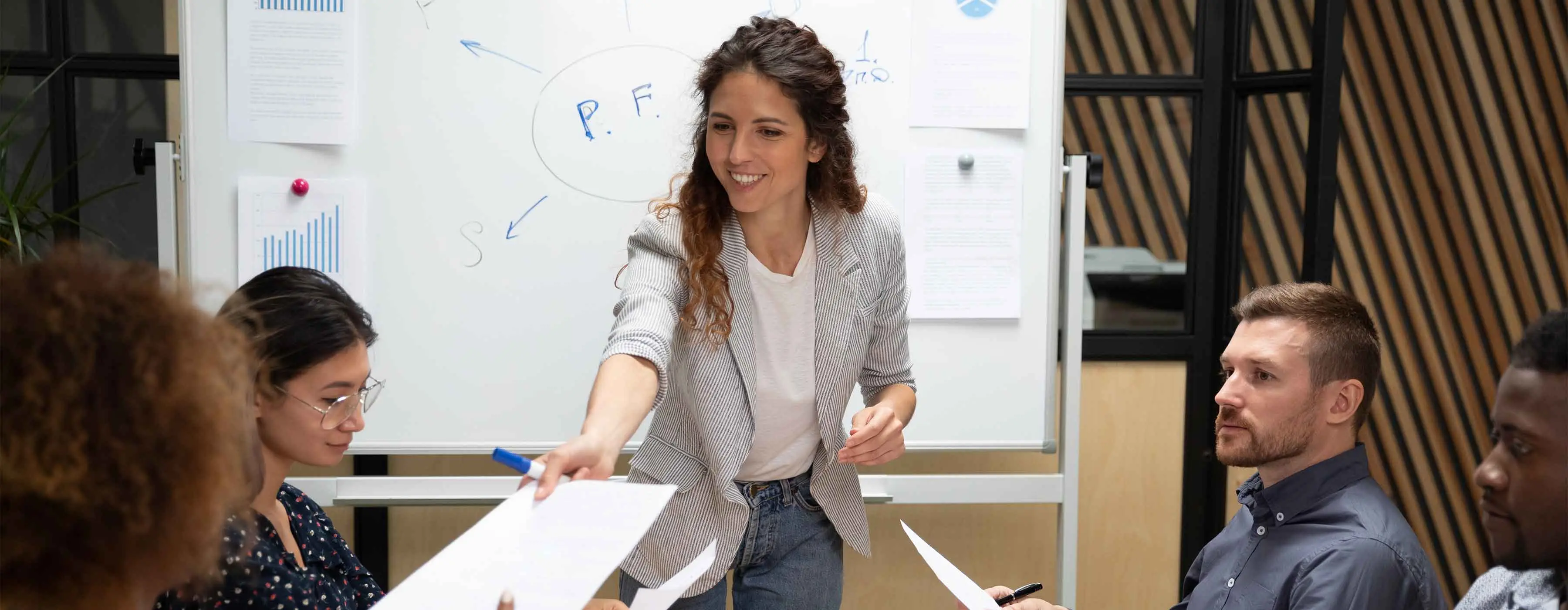 Foto de uma mulher entregando um papel de avaliação para outra mulher.