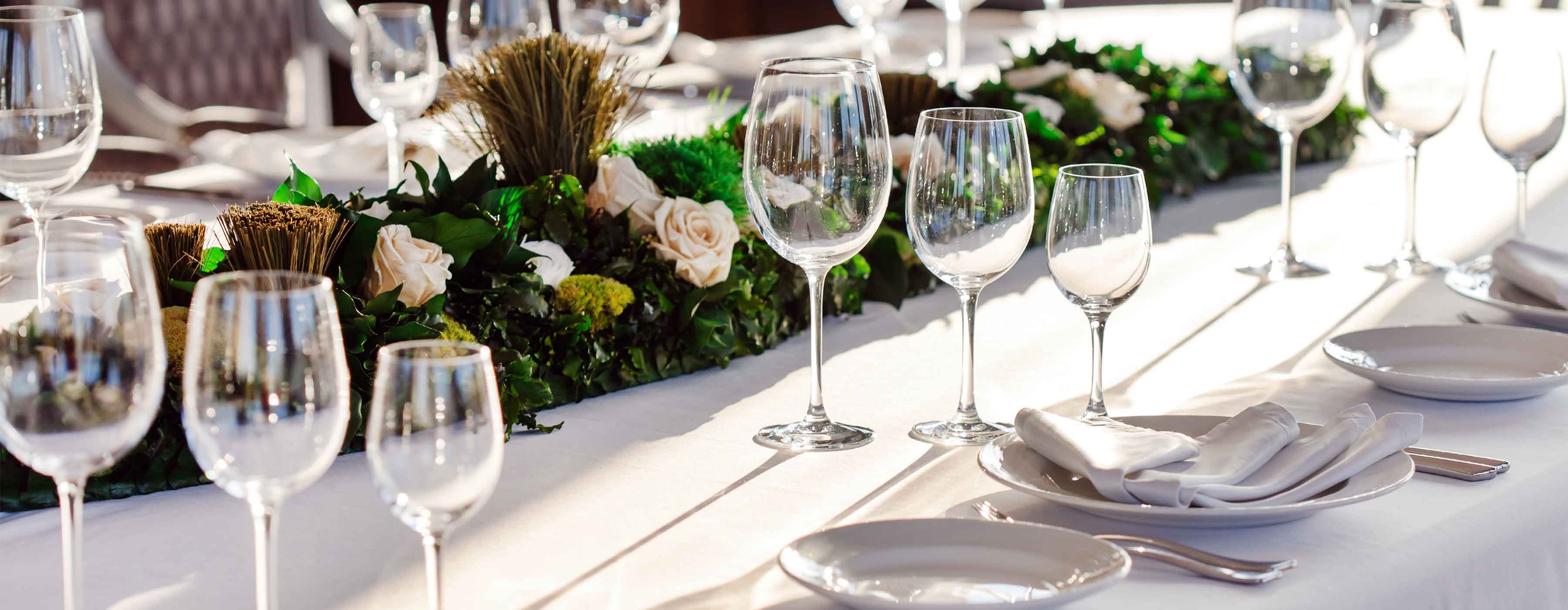 Montagem de Mesas de Buffet e Coffee Break - Foto de uma mesa arrumada com taças, talheres e pratos, e com decoração