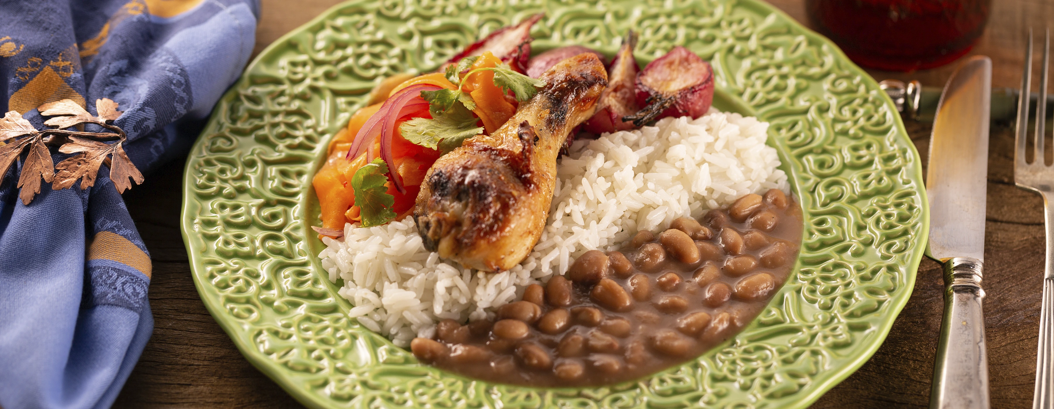 Prato de arroz, feijão, vegetais e uma coxa de frango.