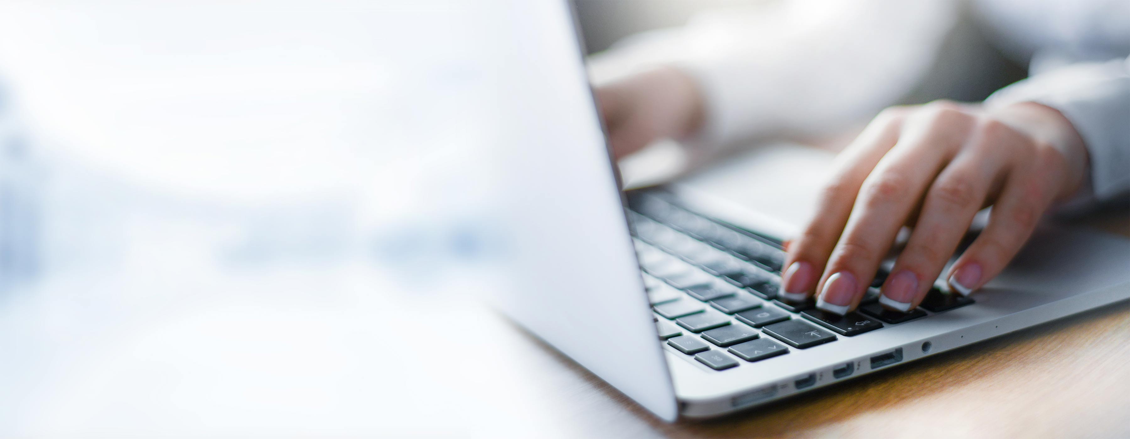 mãos femininas sobre o teclado do notebook