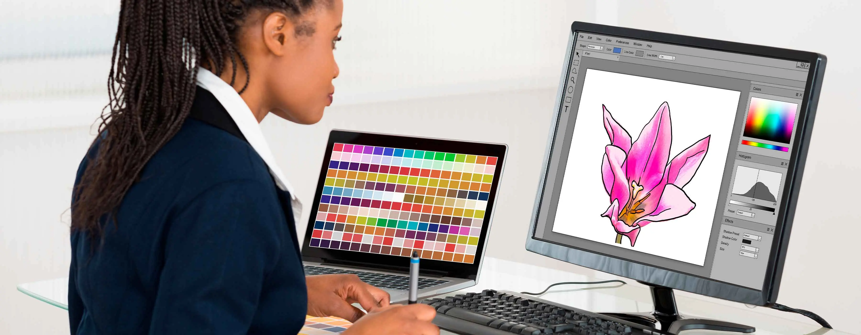 Photoshop - pintura digital - foto de mulher usando mesa digitalizadora enquanto olha um monitor com desenho de uma flor rosa, e um notebook com paleta de cores na tela ao lado