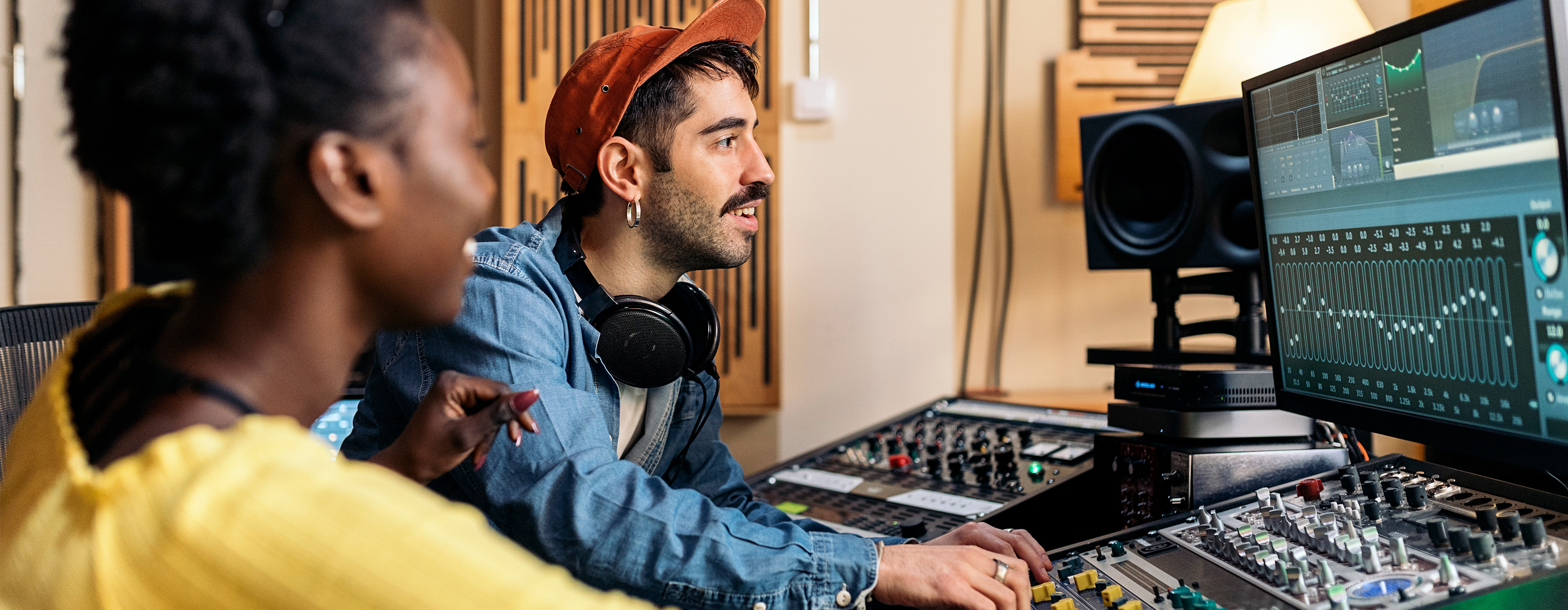 Produção de Música Eletrônica - foto em plano fechado de uma moça e um rapaz editando música em uma mesa de som