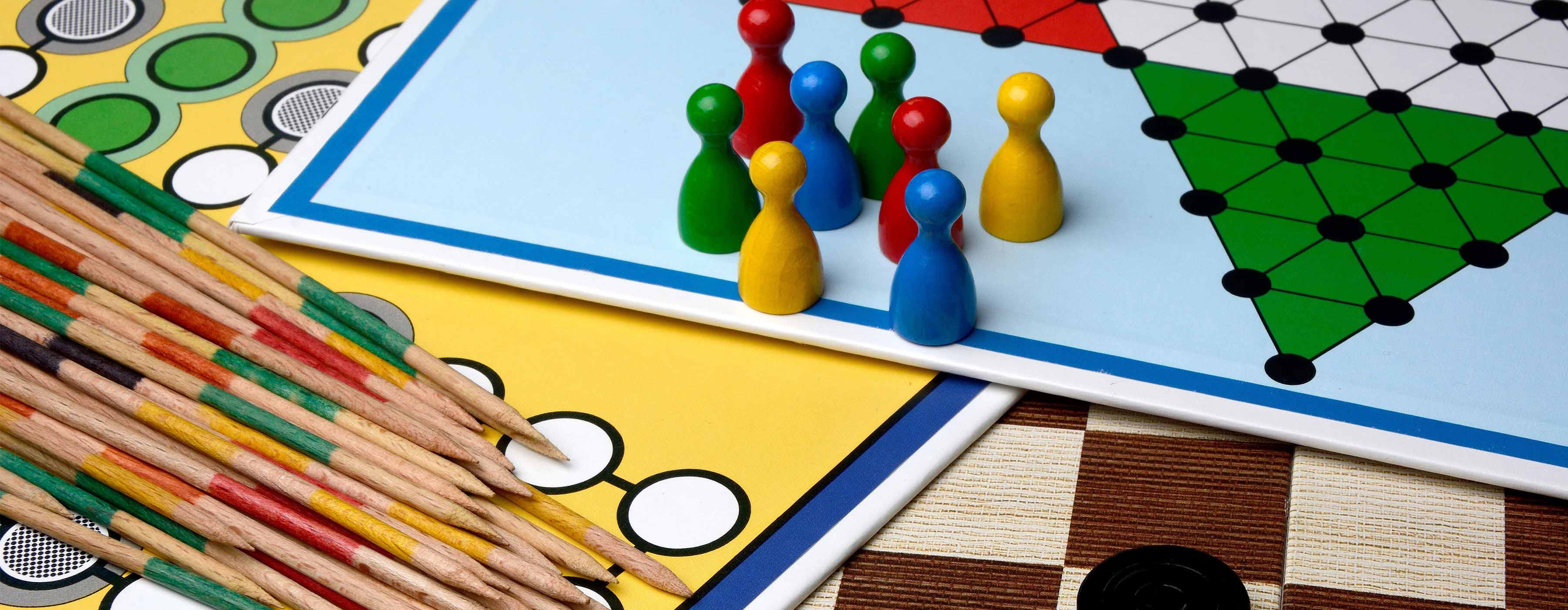 Práticas Recreativas para Festas e Eventos. Imagem em close de tabuleiros e peças de jogos.