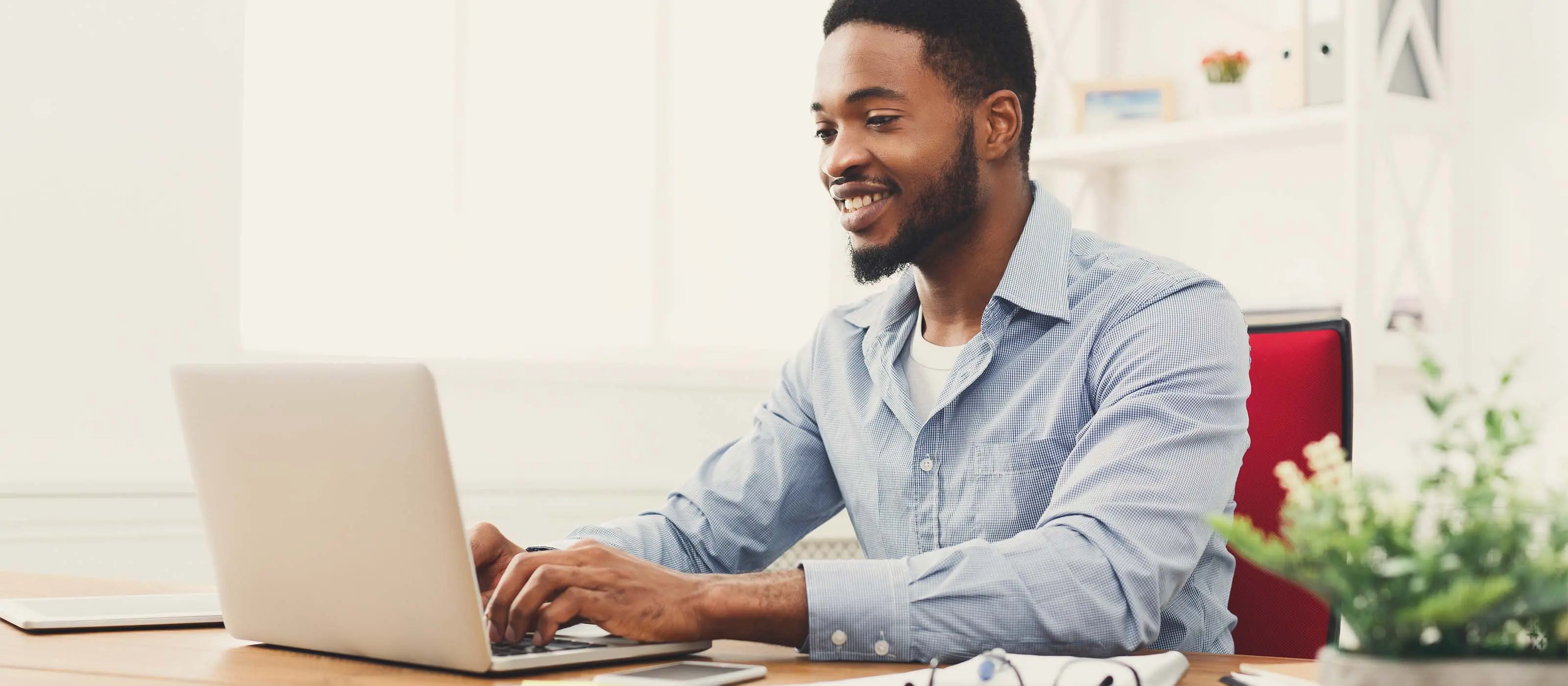 Foto de um homem negro jovem usando o notebook.