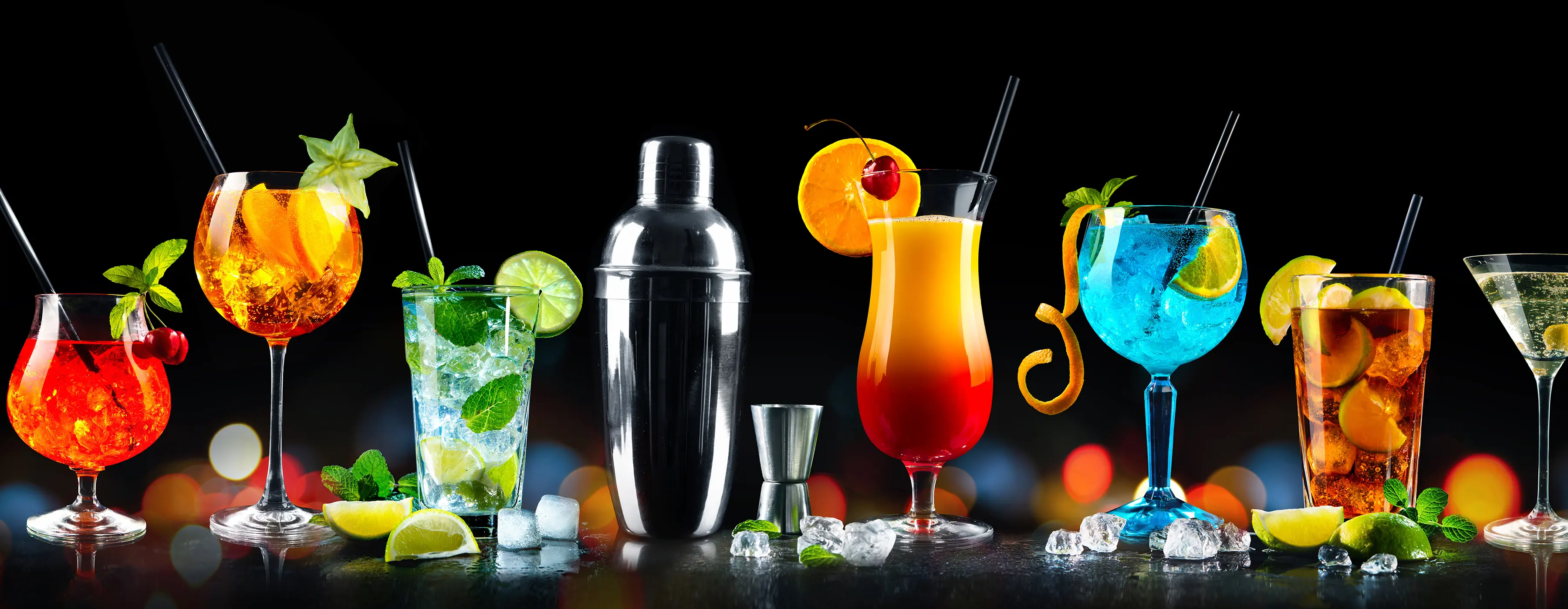 Foto de diversos copos com bebidas e uma coqueteleira