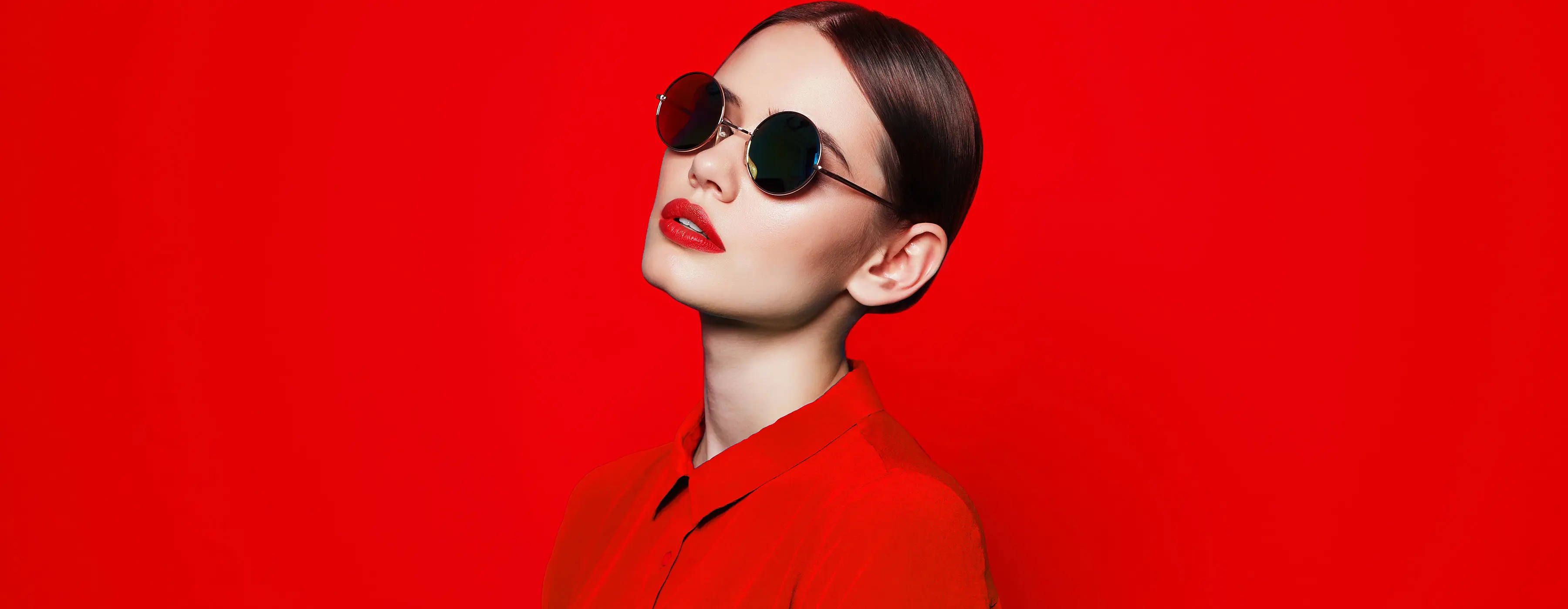 Foto de modelo usando óculos escuro posando para campanha de moda.