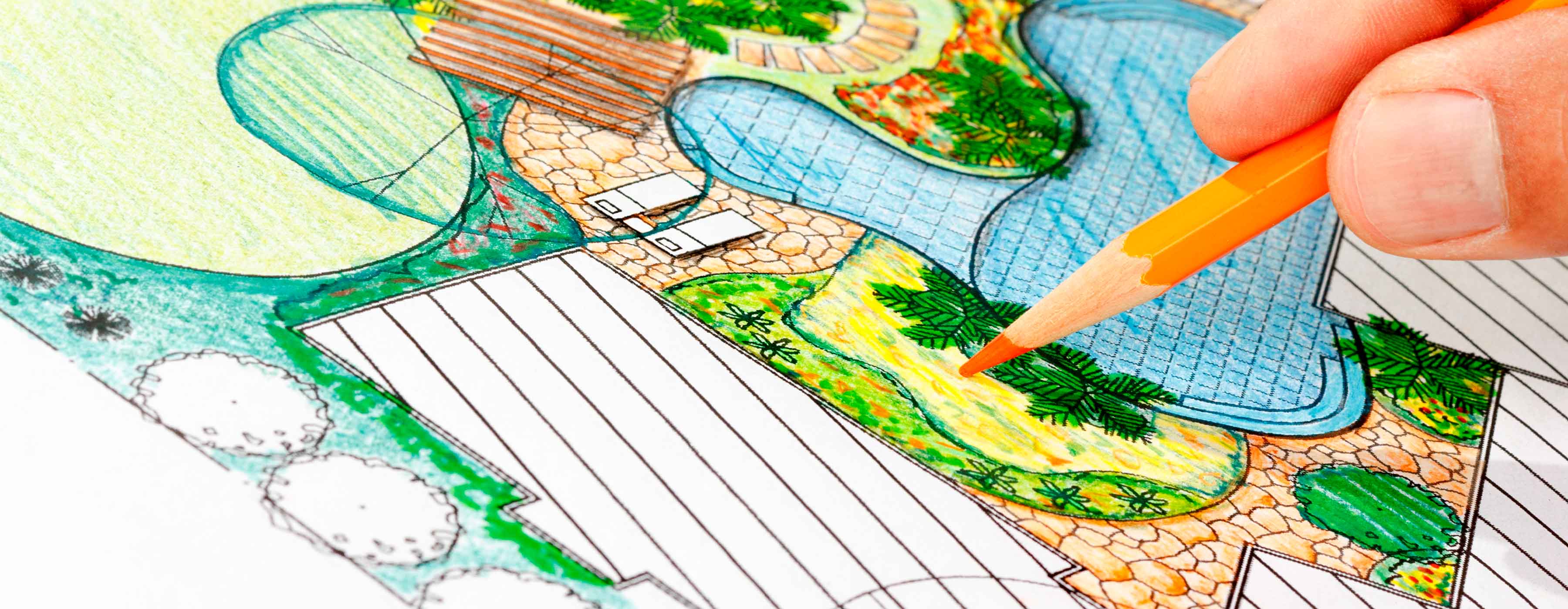 Foto em close da mão de uma pessoa pintando um desenho em cima da mesa.