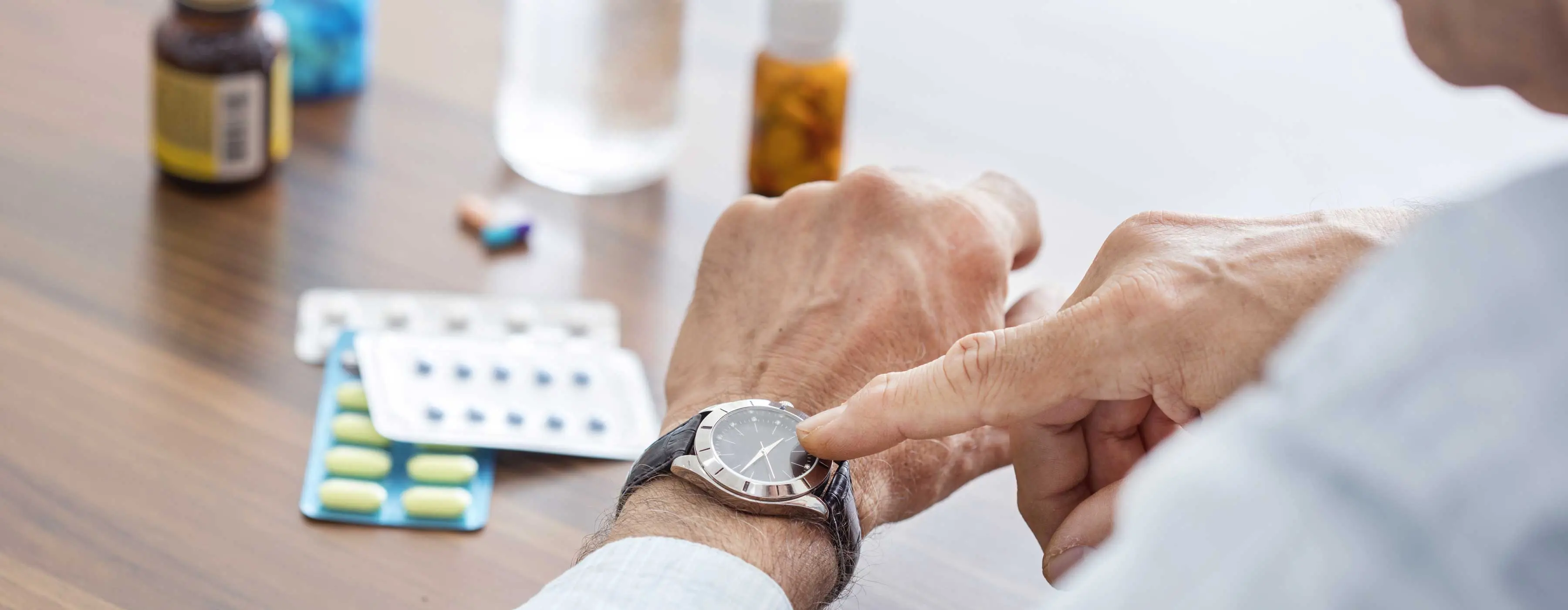 Foto em close de cápsulas de remédio ao lado de uma calculadora e lápis.