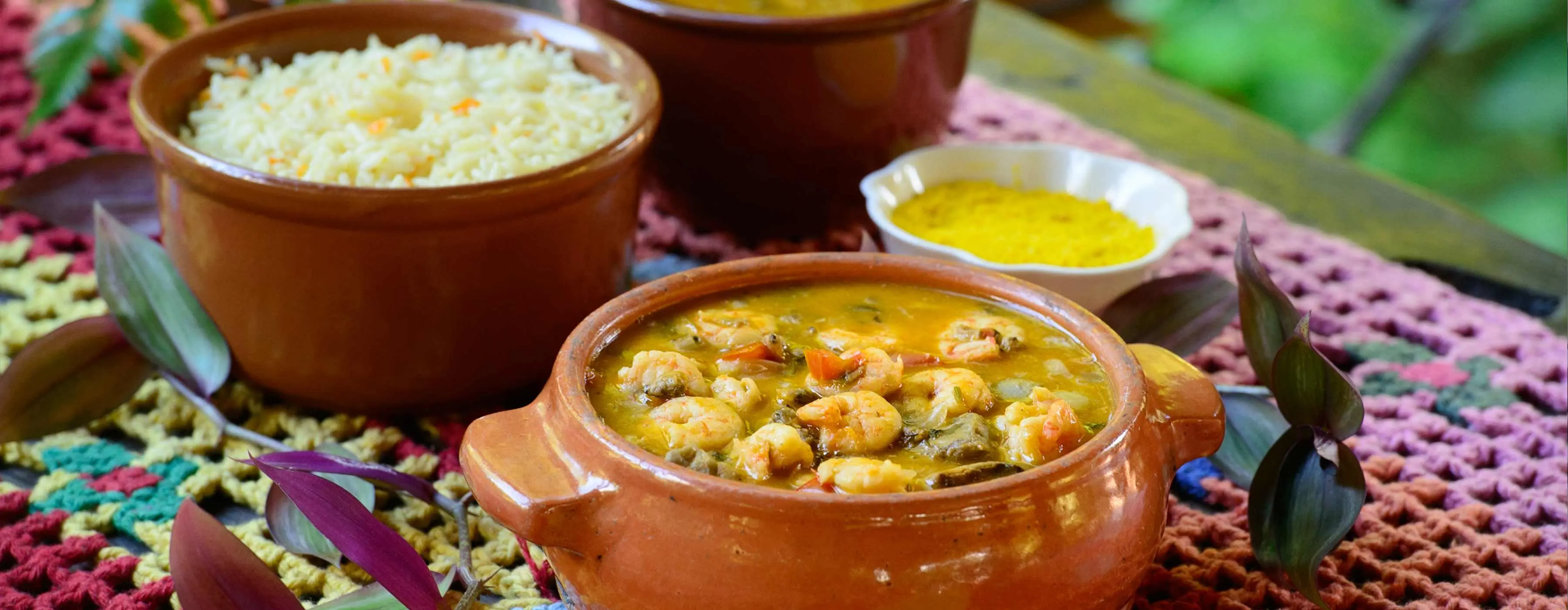 Foto de panelas de barro com bobó de camarão, arroz, farofa e caldo