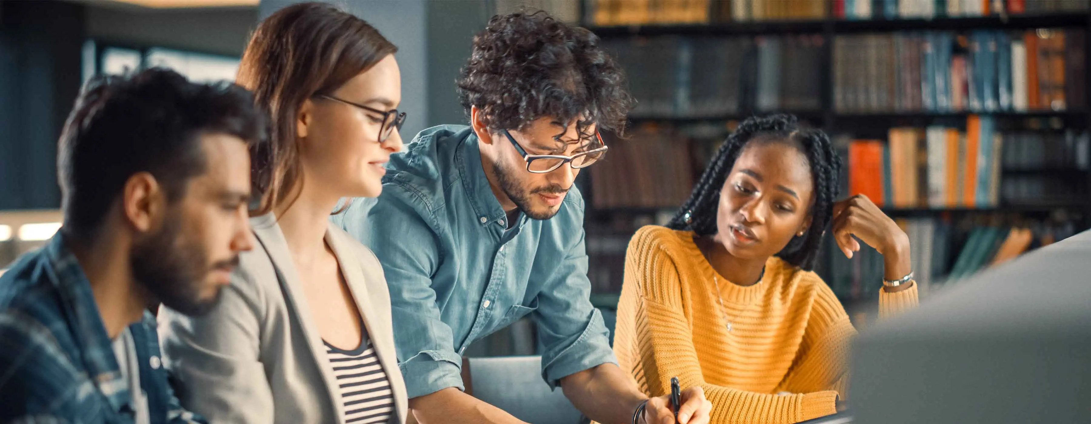 Foto de quatro pessoas estudando lado a lado.