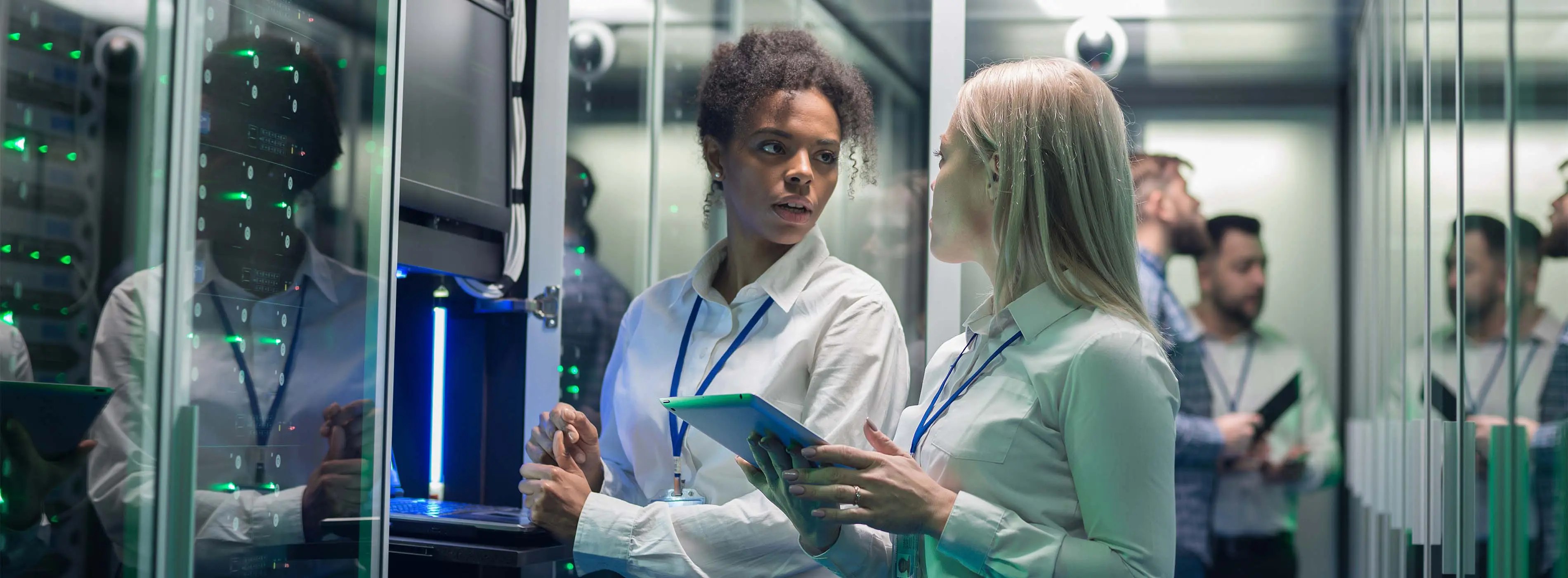 Foto de duas mulheres conversando em frente de um servidor de computadores.