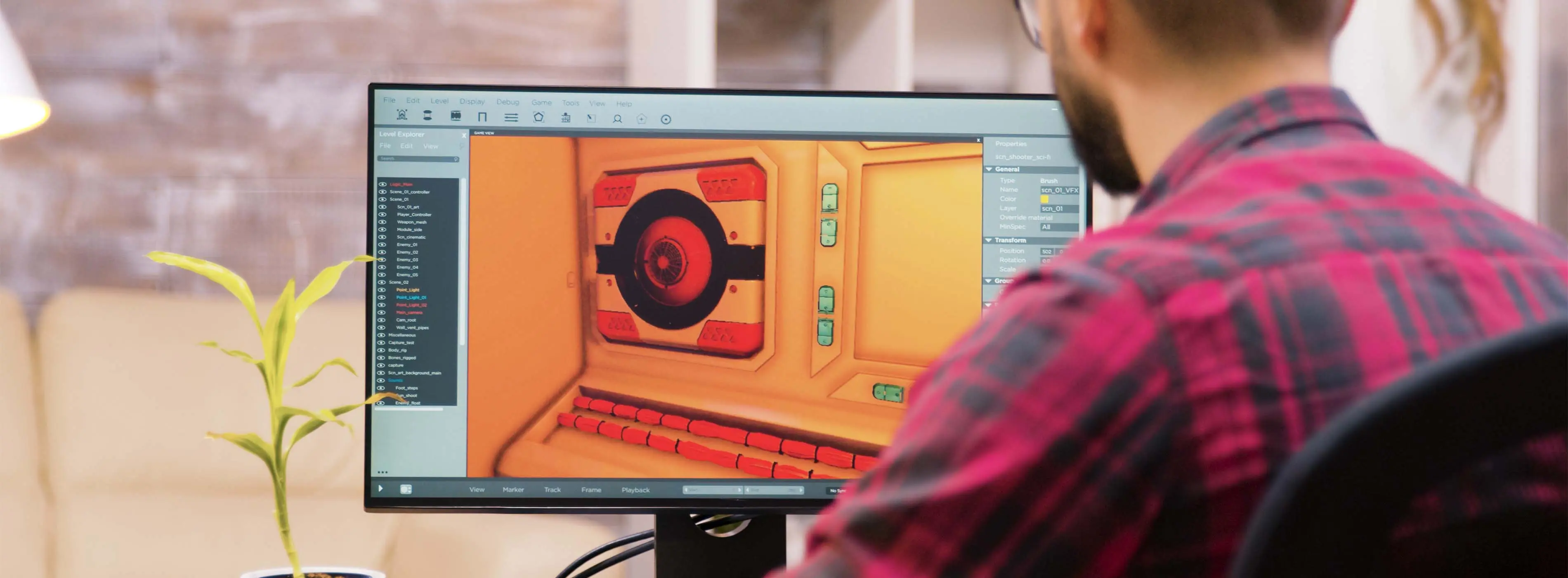 Foto de homem sentado em frente a computador com software de tratamento de imagem na tela.