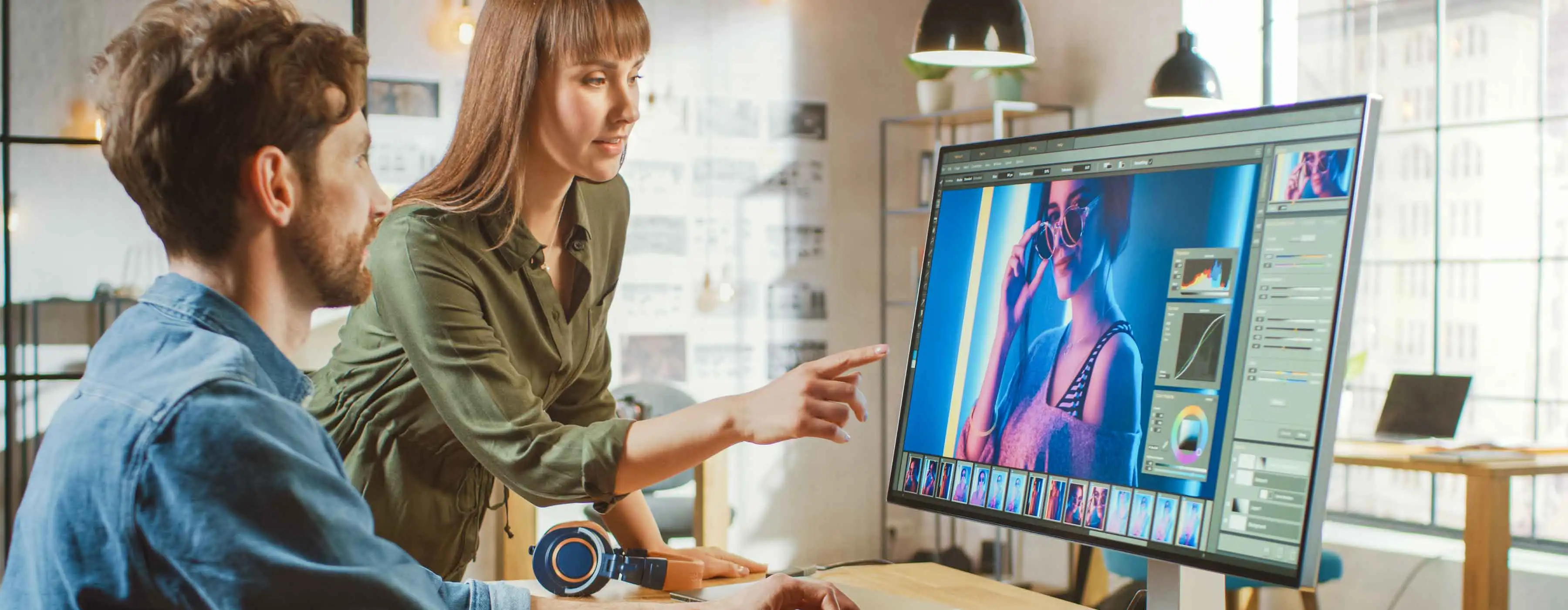 Imagem de um homem e uma mulher editando uma imagem no computador.