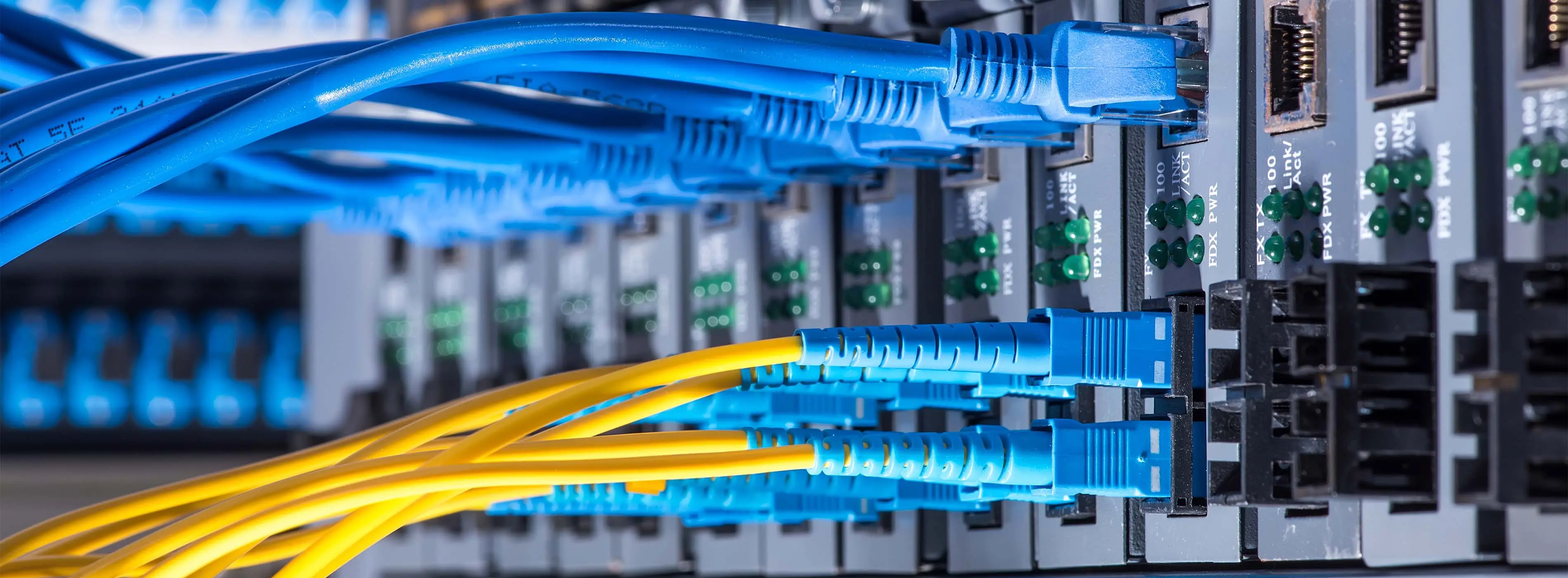 Foto em close de cabos conectados a entradas de computador.