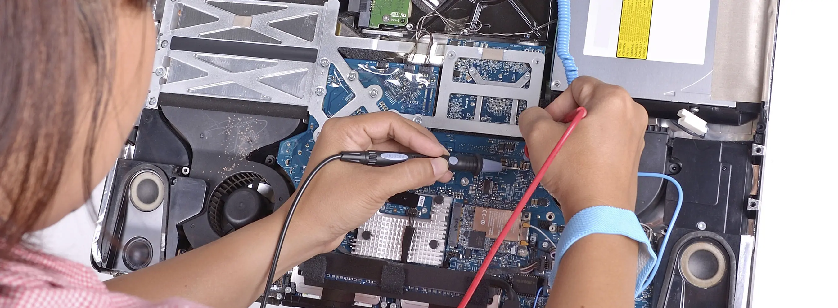 Foto de pessoa manipulando peças de equipamento eletrônico.