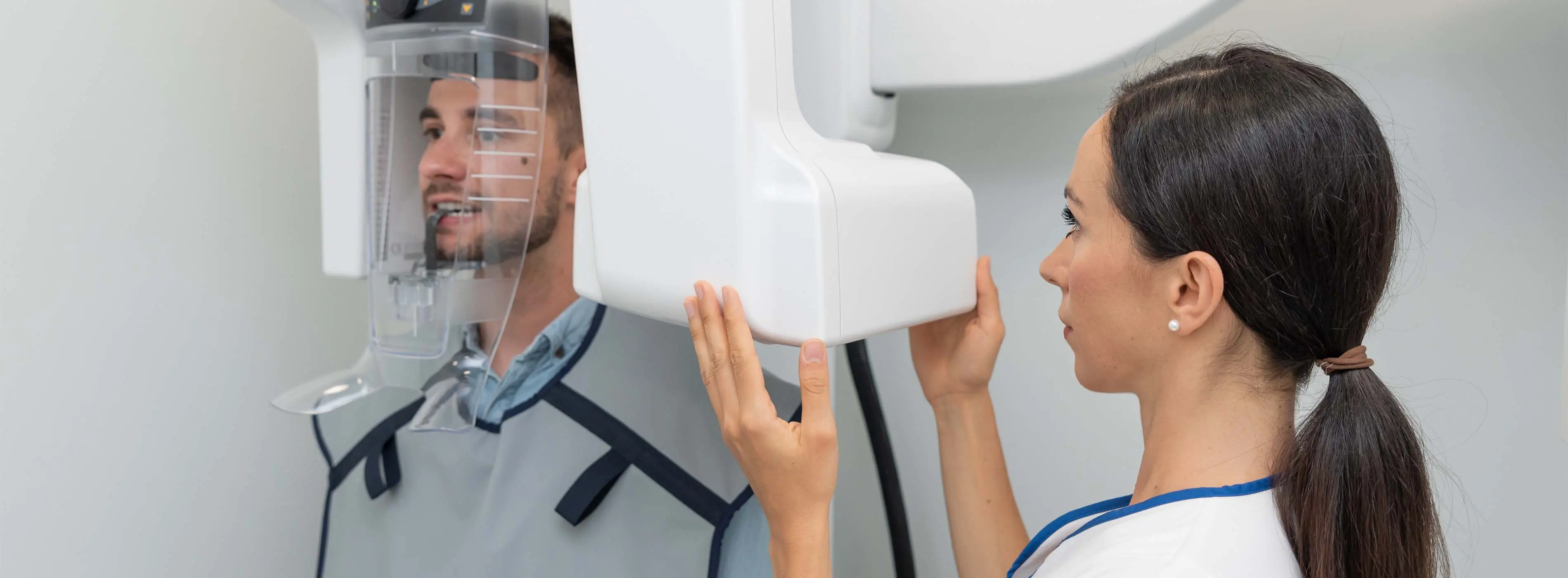  Foto em close de mãos com luvas cirúrgicas manipulando uma prótese dentária utilizando ferramentas de odontologia.