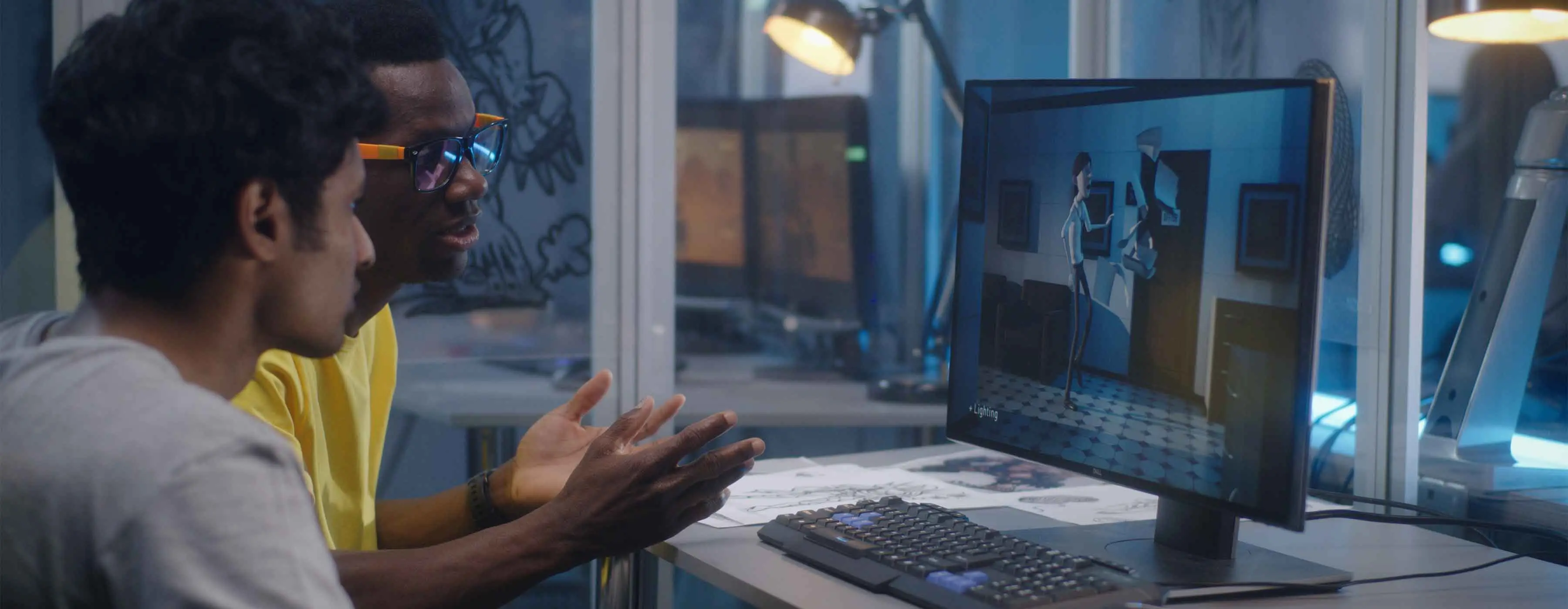 Dois homens assistem uma animação em um computador