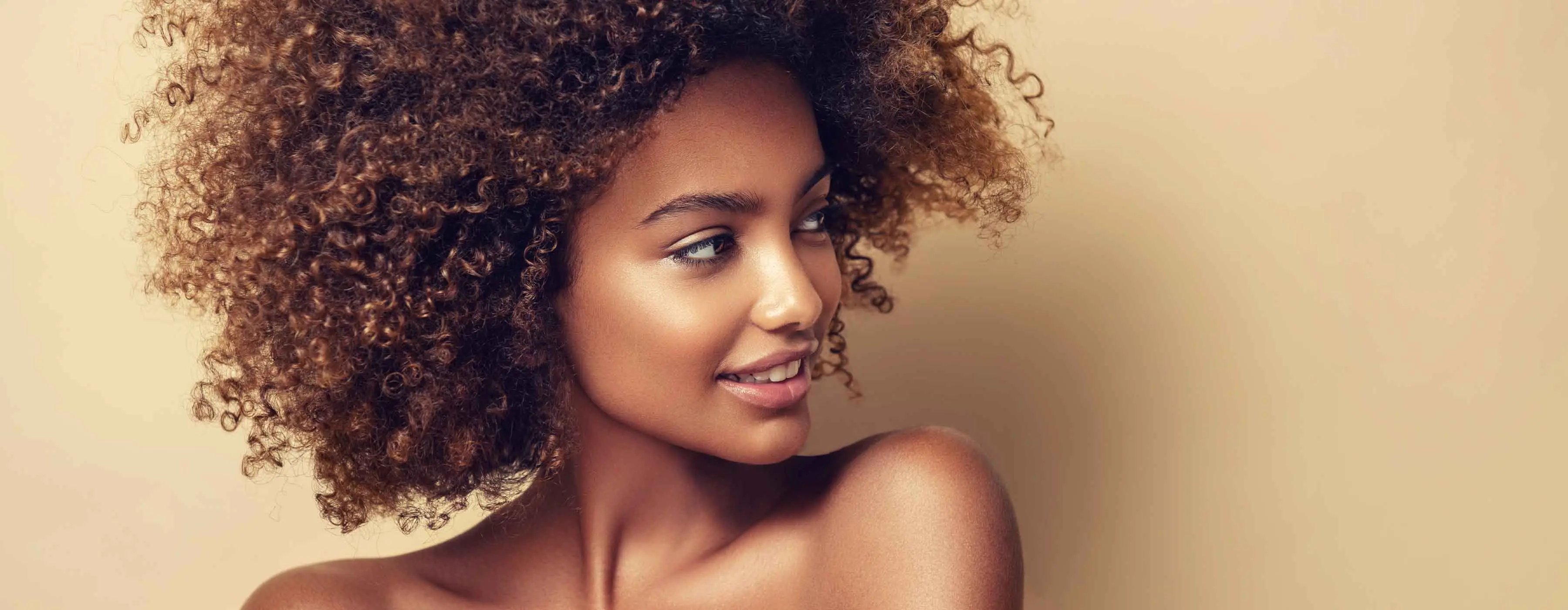 Foto de perfil de uma mulher negra olhando para o lado.