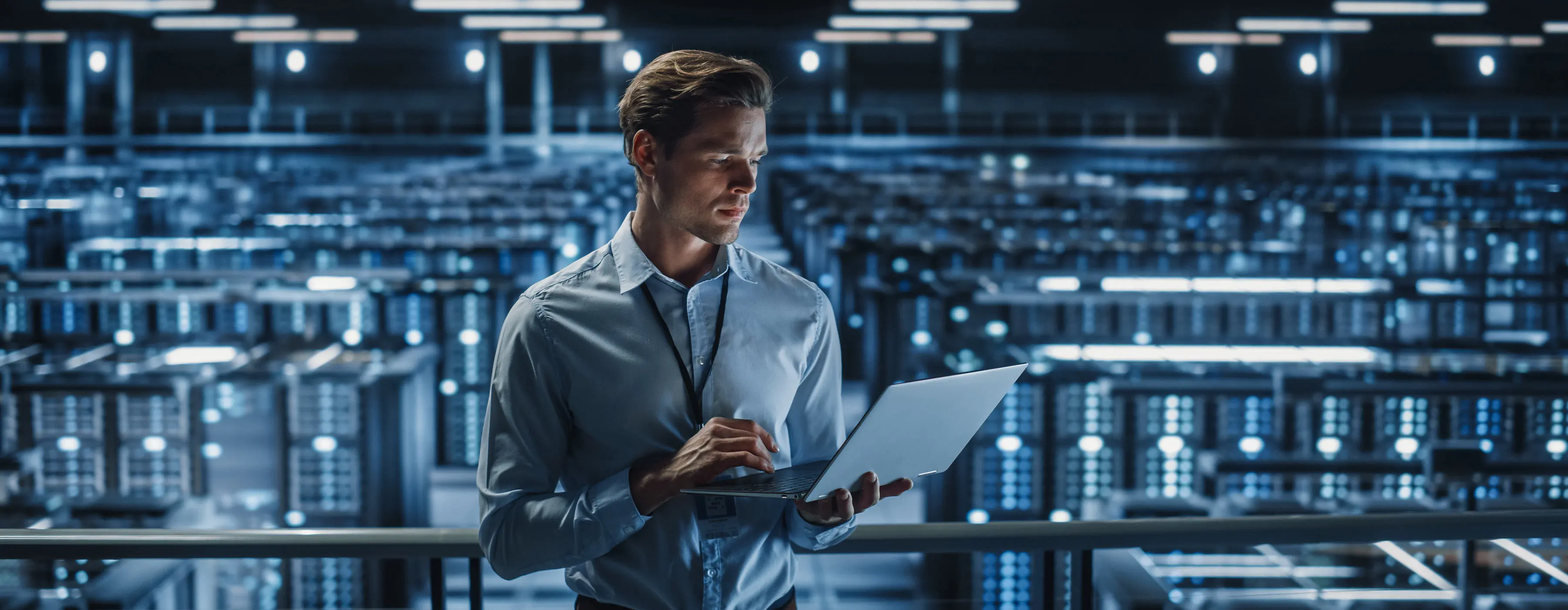 Foto de especialista de TI usando notebook em espaço de data center de empresa.