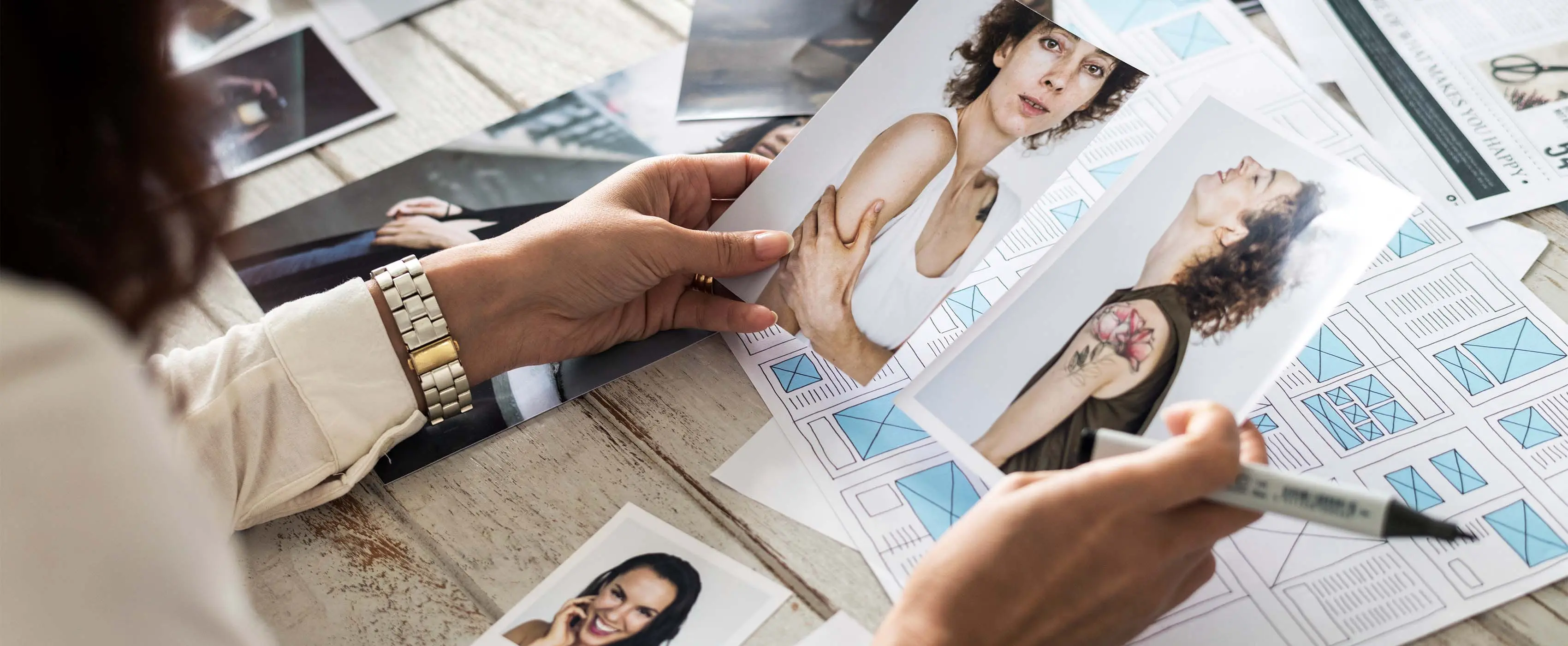 Foto de mulher escolhendo fotos de modelos para inserir em diagramação de publicação.